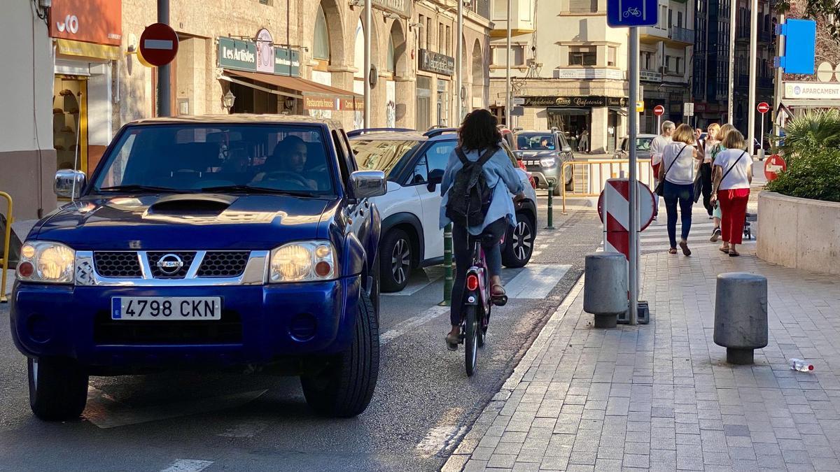 Una ciclista circula por el carril bici cortado de la plaza Comtat del Rosselló