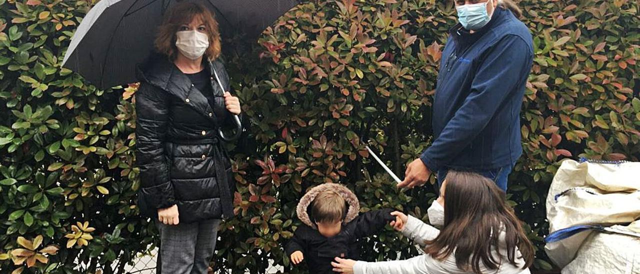 La edil Patricia Martín y César San Miguel, con su familia, ayer, midiendo la altura de su seto, en La Fresneda. | A. I.