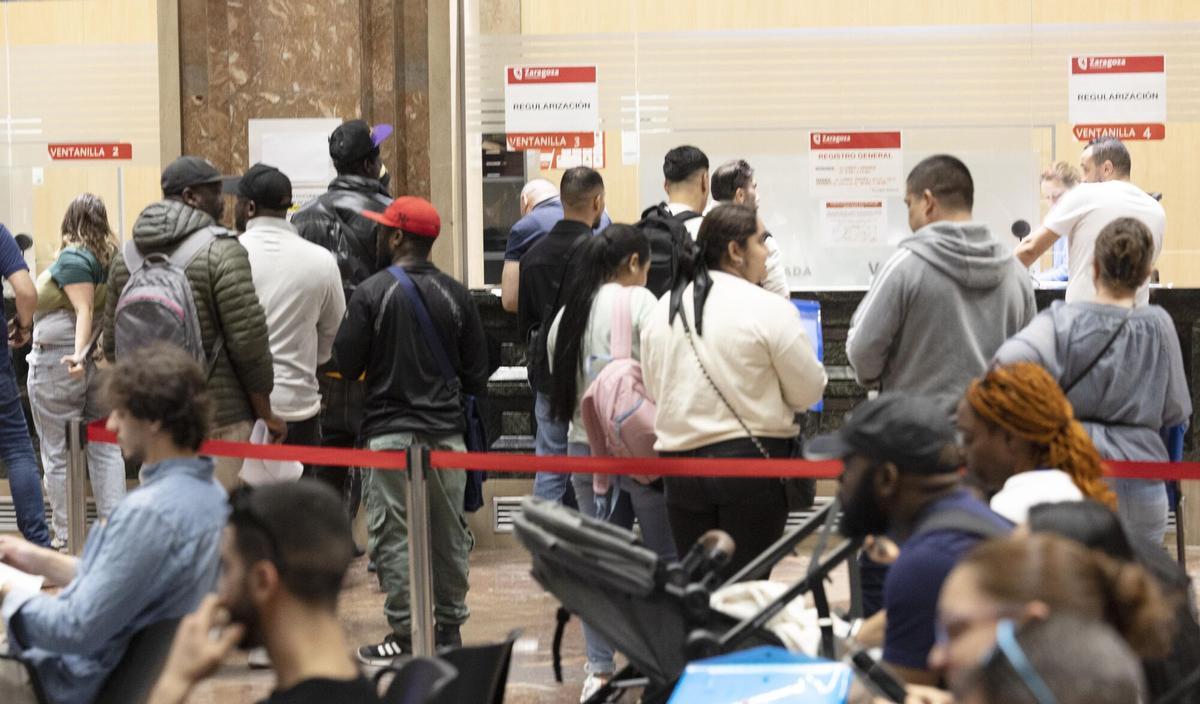Varias personas esperando su turno en el registro del Ayuntamiento de Zaragoza.