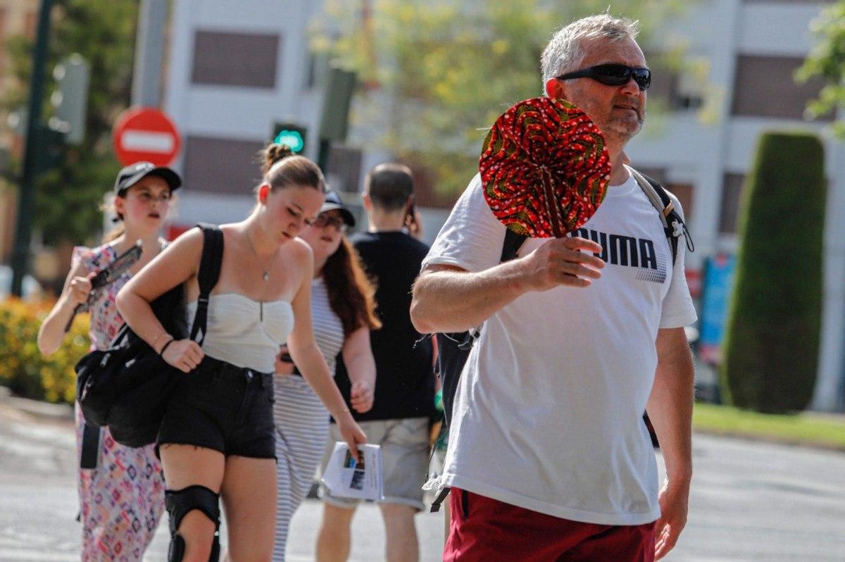 Varias personas caminan por Córdoba a pleno sol.