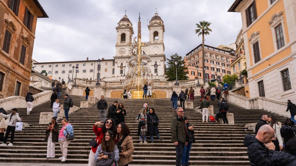 Turistas se hacen selfis en la Plaza de España de Roma