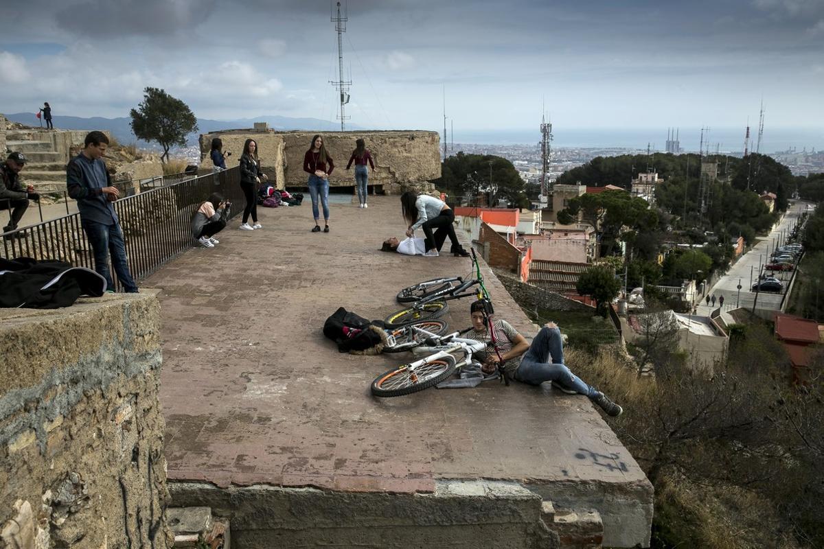 Varias personas contemplan las vistas de Barcelona invadiendo una zona de la batería antiaérea de acceso restringido.