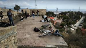 Varias personas contemplan las vistas de Barcelona invadiendo una zona de la batería antiaérea de acceso restringido.