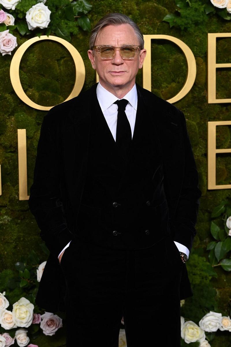 No pasan los años para Daniel Craig, que ha optado por un traje y gabardina negros