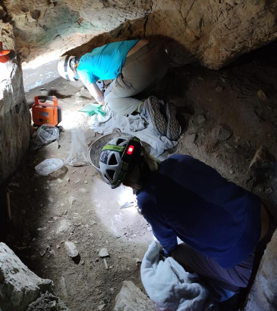 Dos especialistas trabajan en la cueva.