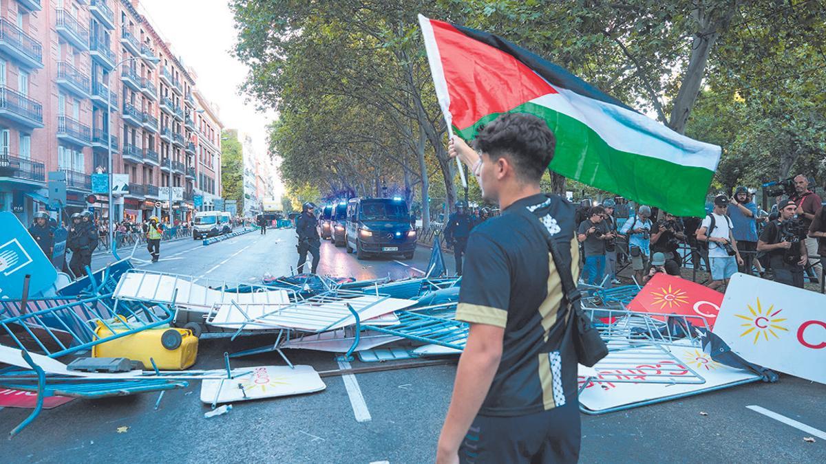 Un joven con una bandera de Palestina, el día de la etapa 21 de la Vuelta Ciclista a España en Madrid