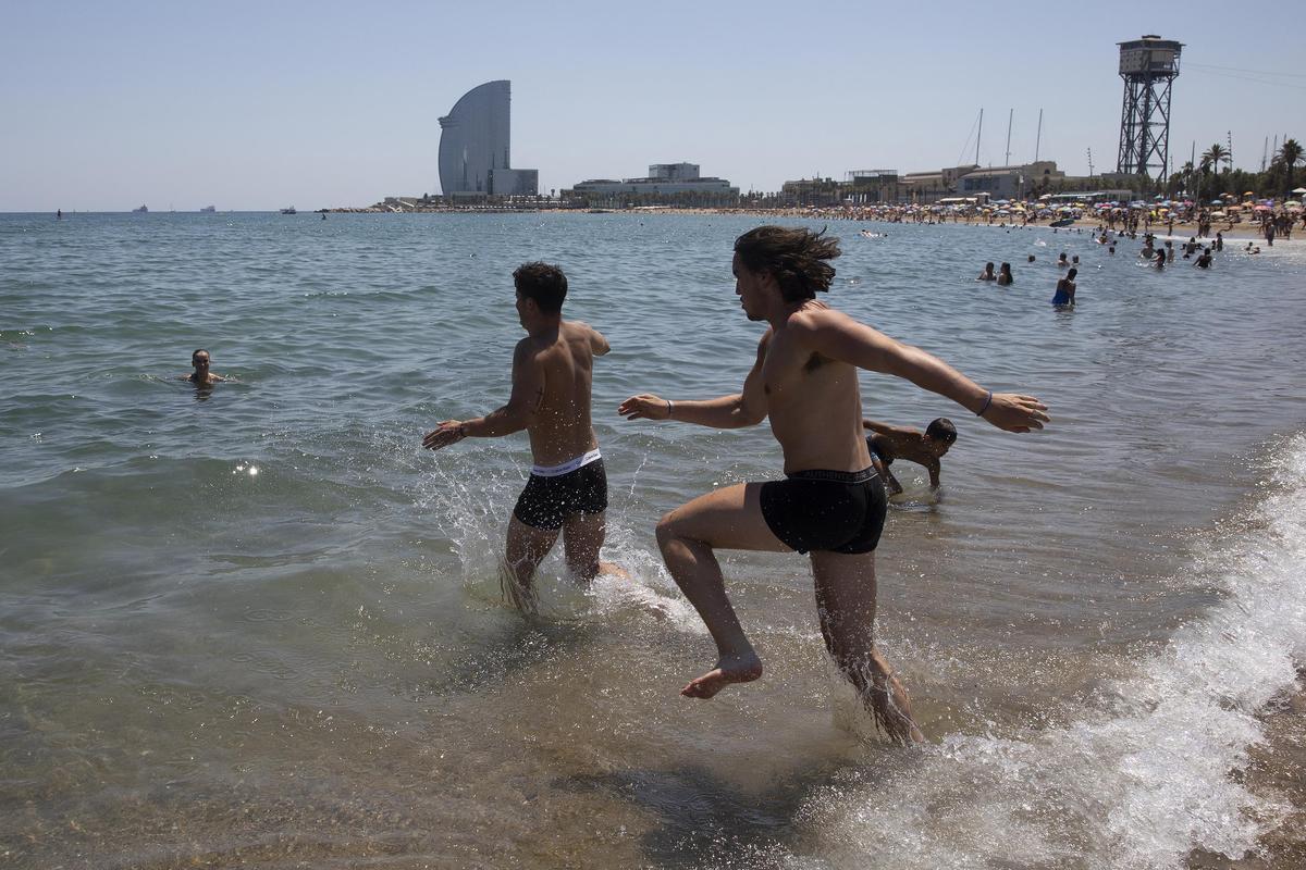 Unos bañistas en la playa de Sant Sebastià de la Barceloneta,hoy
