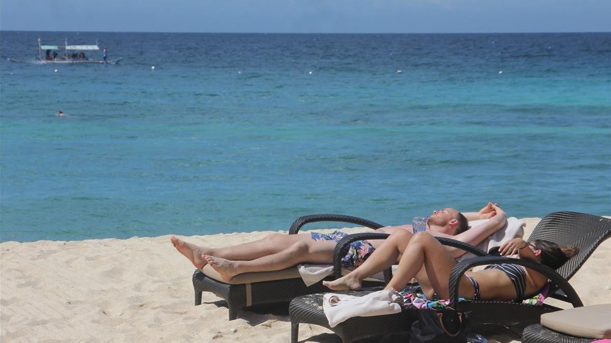 Una pareja de turistas toman el sol en una de las playas de Boracay, en enero del 2018.