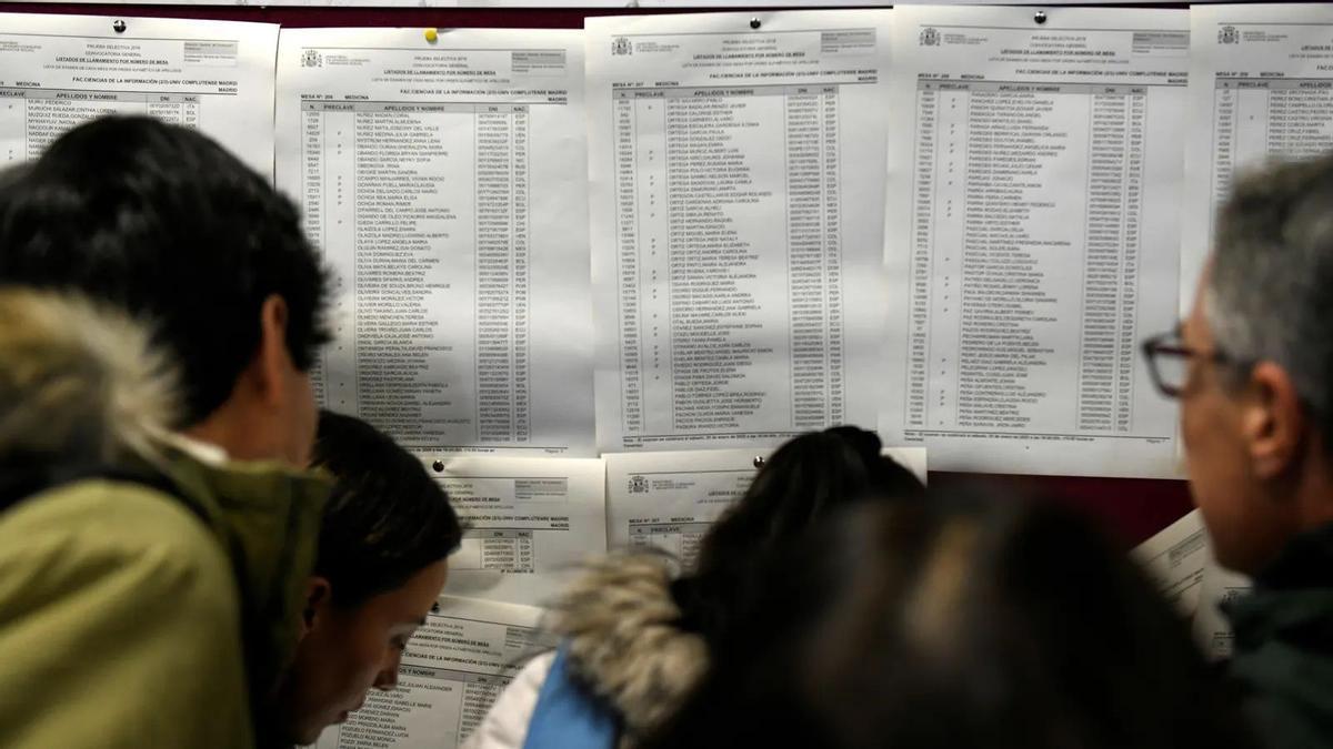Varios estudiantes miran las listas para ver el aula en el que se examinan del mir, en una imagen de archivo.