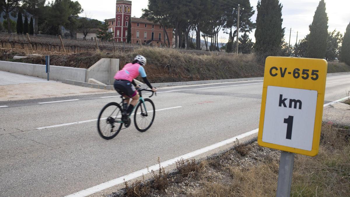 Un ciclista atraviesa la carretera CV-655 en Fontanars dels Alforins.