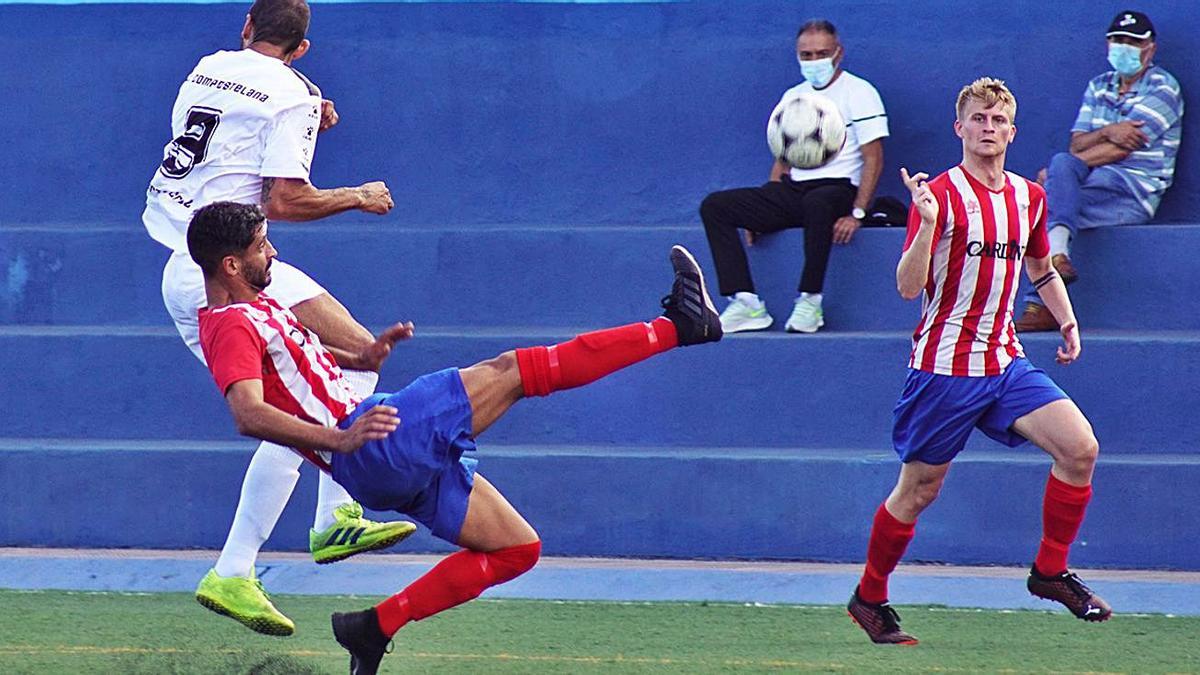 El defensa visitante Hugo despeja el balón ante el atacante del Puerto Cruz, Kiko Ratón. | | ANDRÉS. DÉVORA