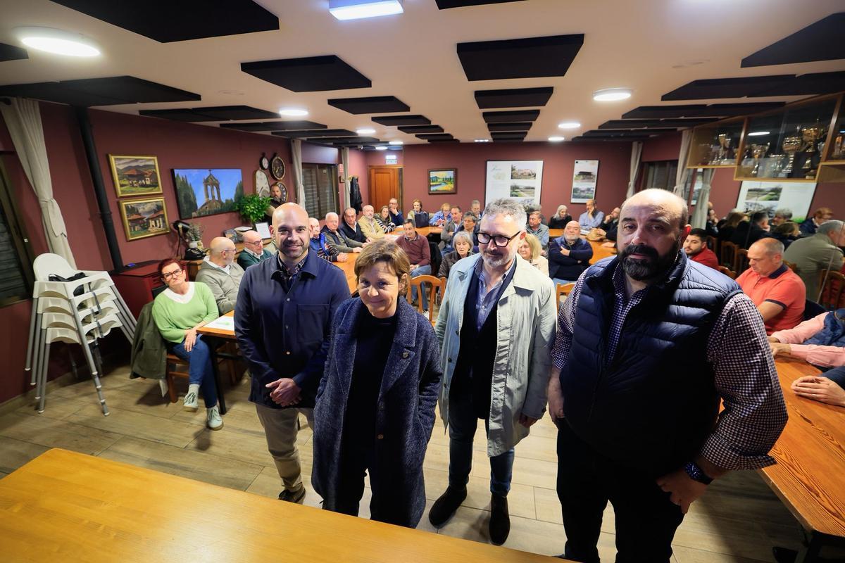 Carmen Moriyón entre los ediles Jesús Martínez Salvador y Gilberto Villoria y el líder vecinal José Luis Nicieza, con el resto de los miembros de "Les Caseríes" al fondo.