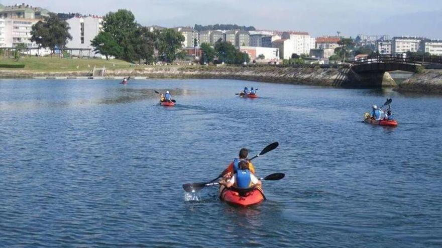 Jóvenes practican kayak por la ría de O Burgo