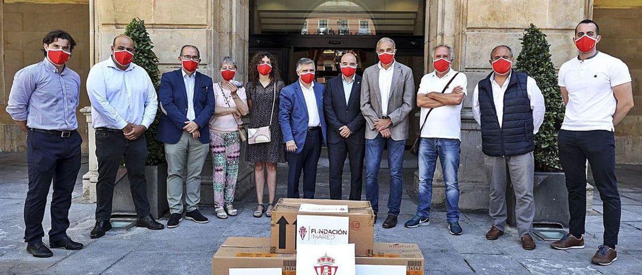 Por la izquierda, Caco Morán, Óscar García, Miguel Lastra, Claudia González, Mónica Cabero, Ruperto Iglesias, Santos Tejón, Joaquín, Lorenzo Pañeda, Germán Robles y Diego Fuertes, ayer, en la plaza Mayor, durante la entrega de las mascarillas a los serenos por parte de la Fundación del Sporting.