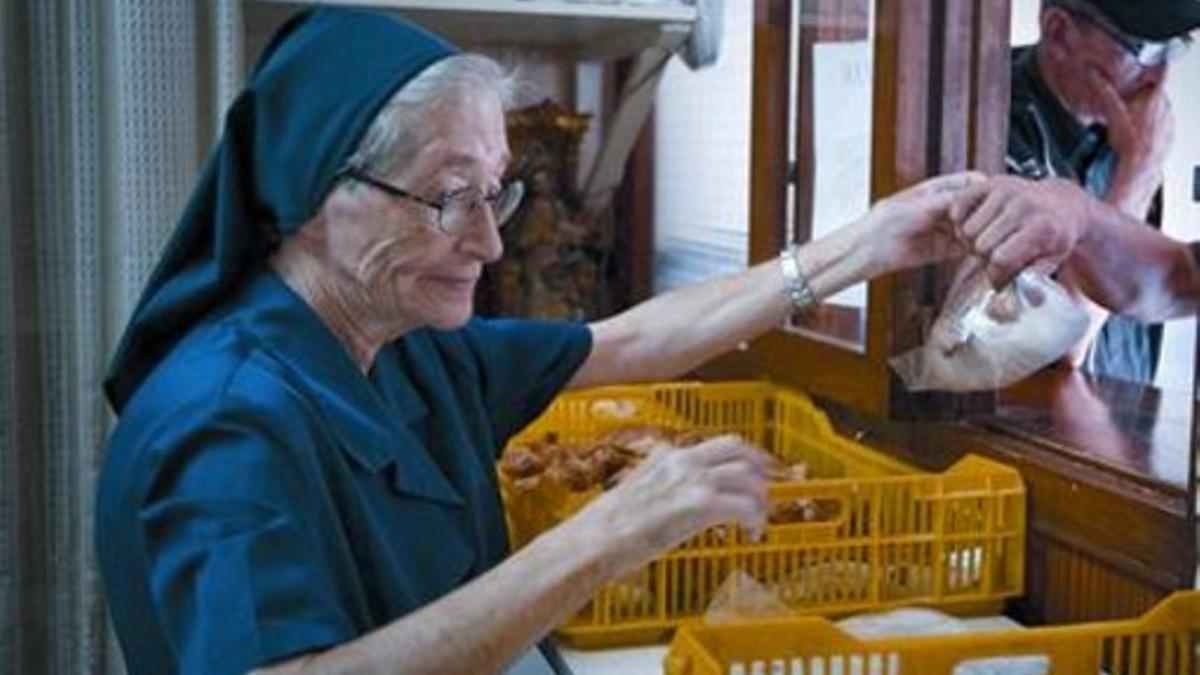 Una religiosa de las Hermanas de la Caridad reparte bocadillos, ayer.