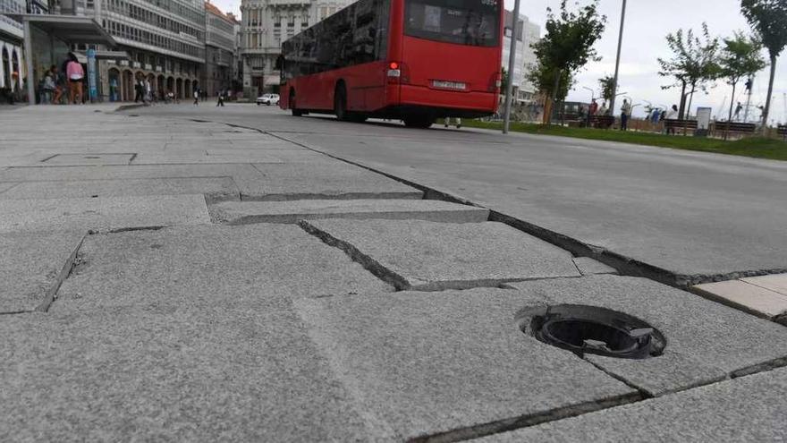 Un autobús pasa por la zona de la Marina deteriorada por el paso de los vehículos.