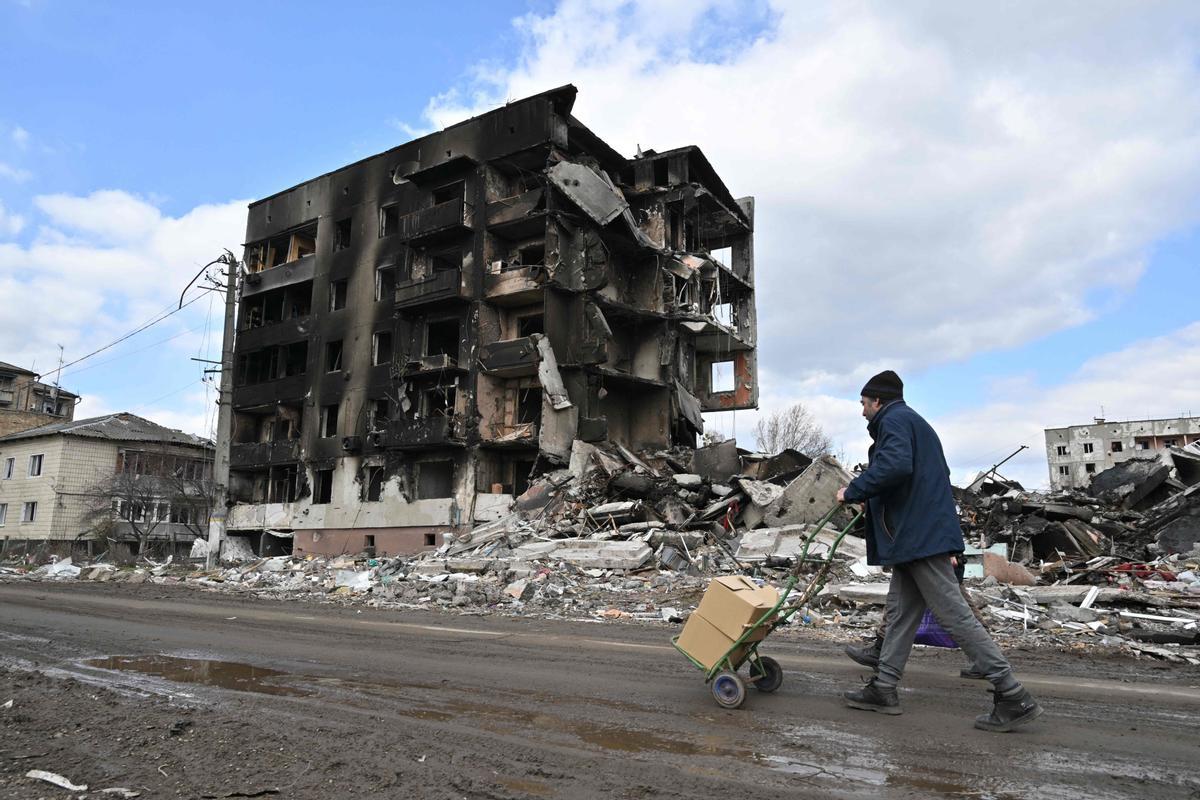 La gente pasa frente a los edificios destruidos en la ciudad de Borodianka, al noroeste de Kiev.