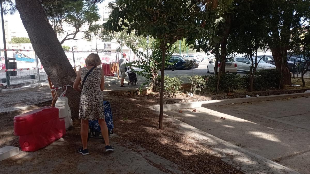 Unos vecinos cruzan una pequeña zona ajardinada camino del mercadillo de Virgen de Belén de los miércoles, a causa de las obras.