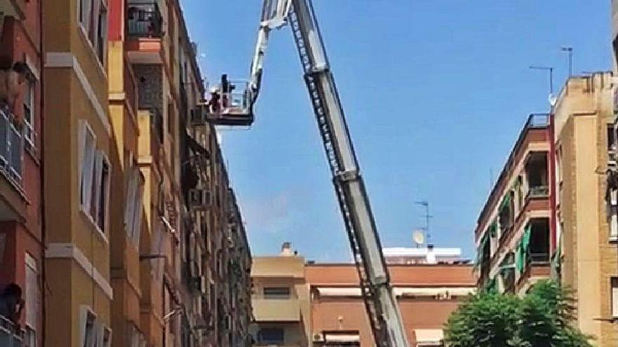 Los bomberos rescatan con la escalera a una de las vecinas.