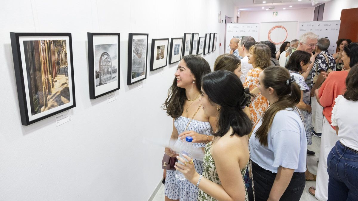 Asistentes contemplan las fotografías de la exposición 'La mirada aprendida'