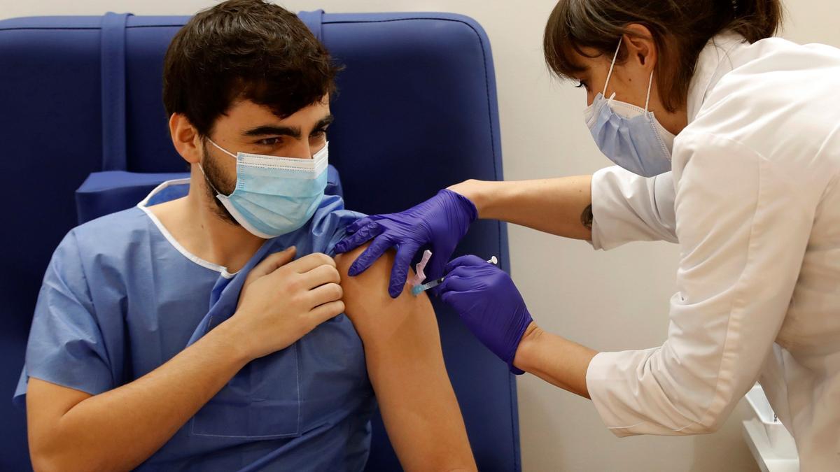 Una enfermera del Hospital Clinic de Barcelona administra la primera dosis de la vacuna Pfizer-BioNTech a un sanitario en la campaña de vacunación del propio hospital a su personal.