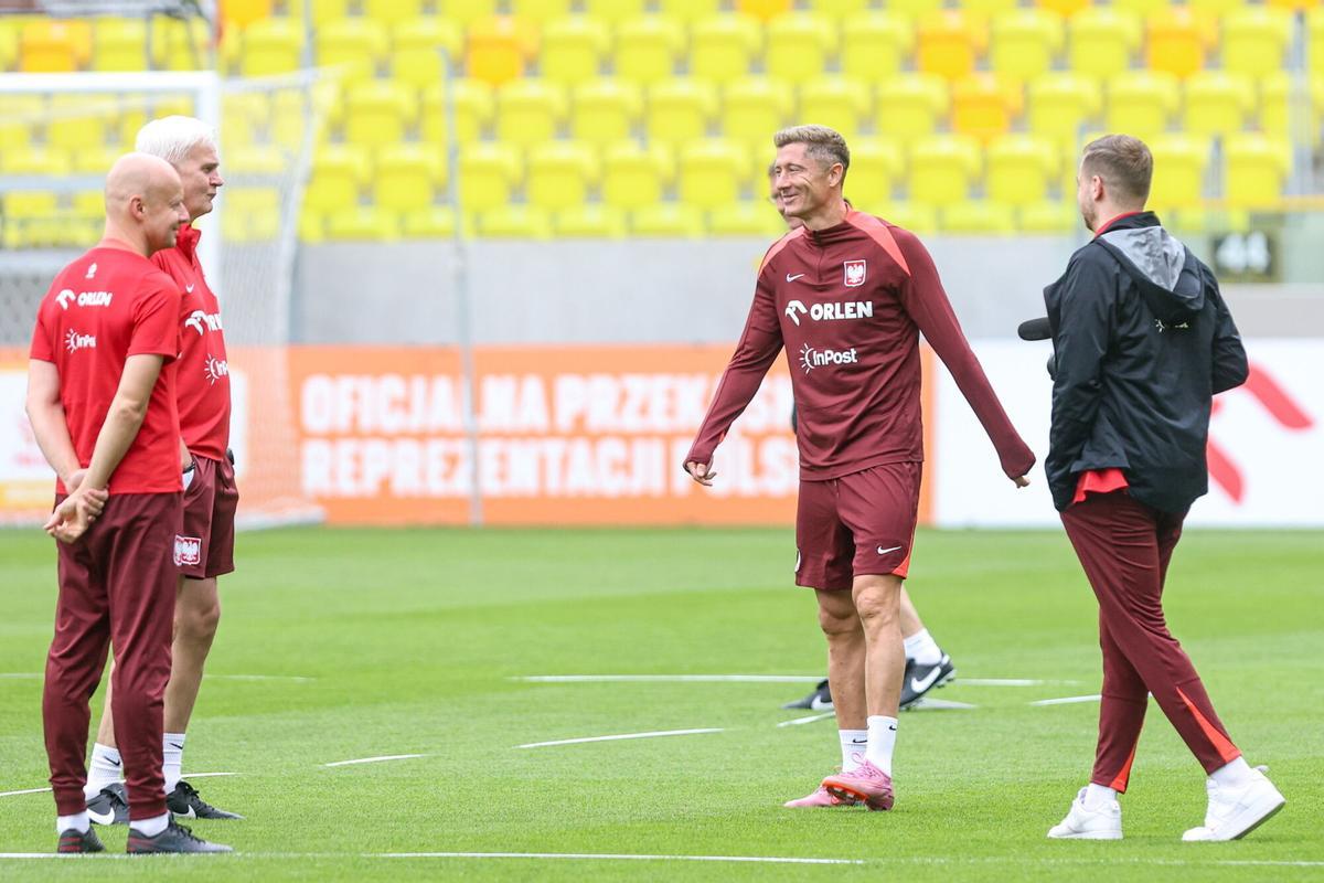 Robert Lewandowski habla con técnicos de la selección en el último entrenamiento de la selección polaca en Katowice.