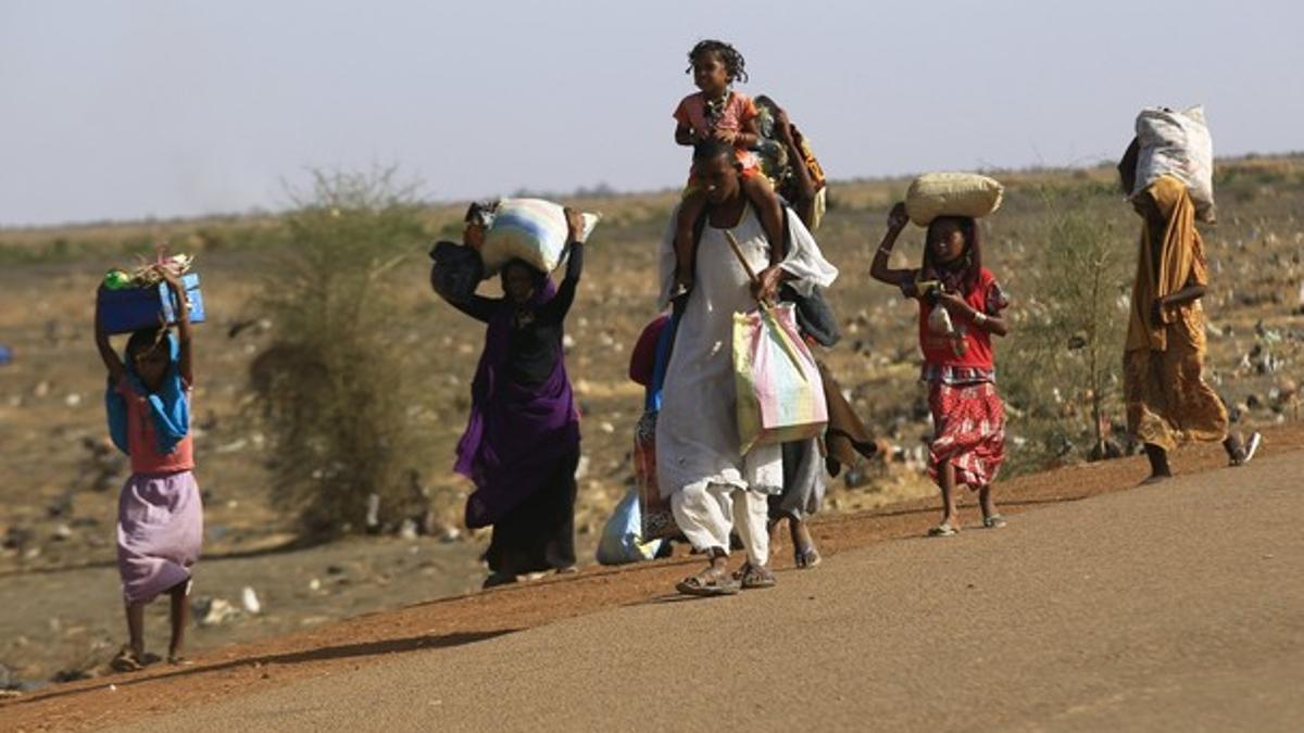 Una familia huye de un ataque rebelde en la ciudad sursudanesa de Rank, el pasado viernes.