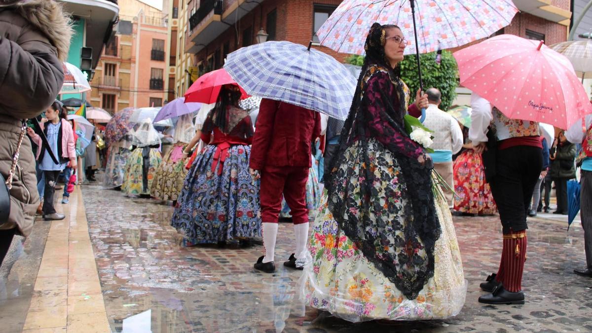 Las falleras se resguardan de la lluvia en plena Ofrenda 2025 de Alzira.