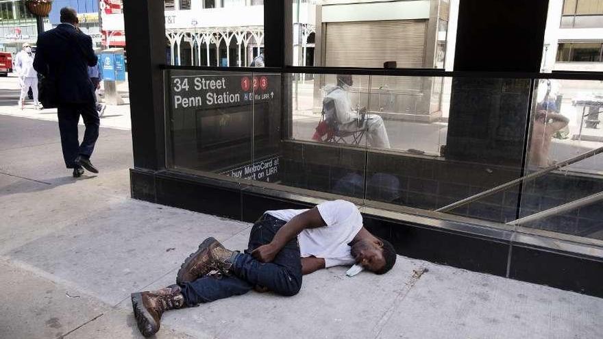 Un hombre yace en el suelo junto a una estación de metro, ayer en Nueva York.