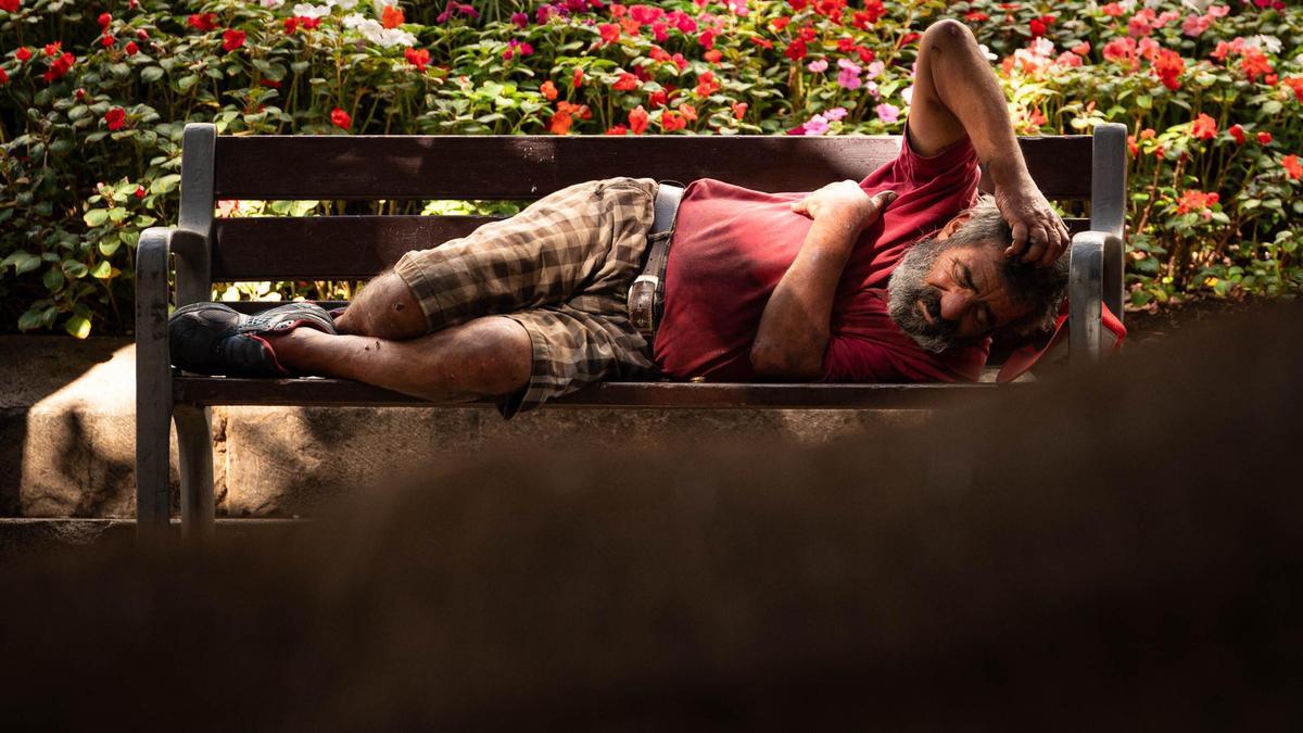 Una persona sin hogar duerme en un banco de Santa Cruz de Tenerife.