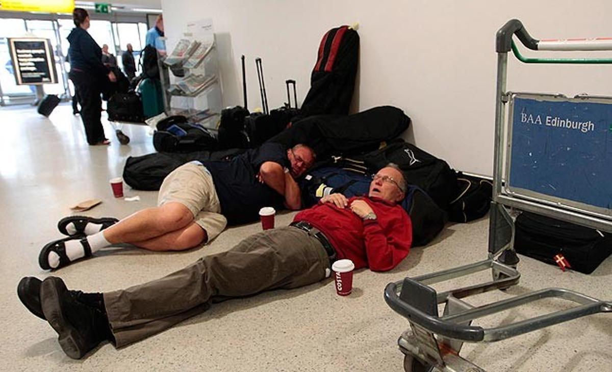 Dos homes dormen aquest dimarts a l’Aeroport d’Edimburg, a Escòcia, a causa de les cancel·lacions produïdes per la pluja de cendra produïda pel volcà islandès Grimsvoetn.