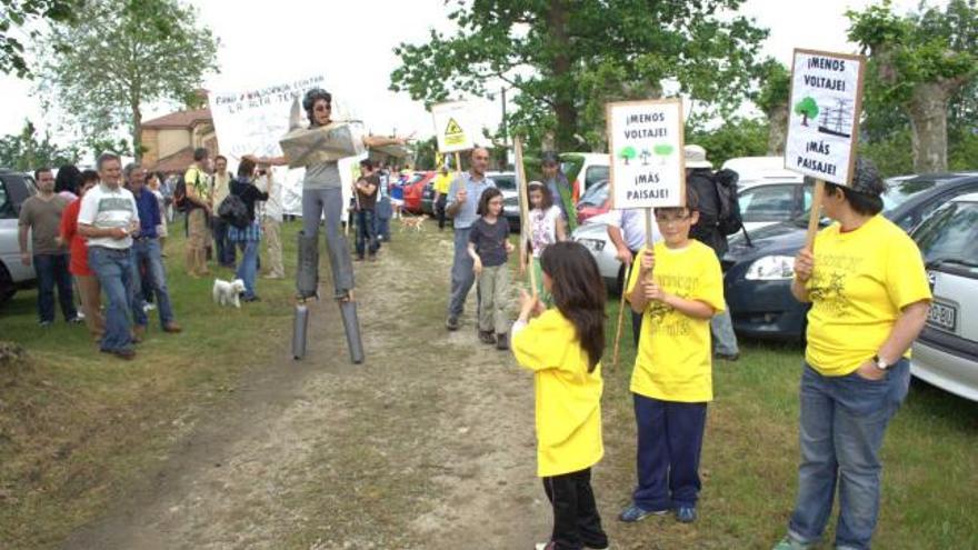 Un grupo de manifestantes, con una torre de alta tensión al fondo, durante la marcha.