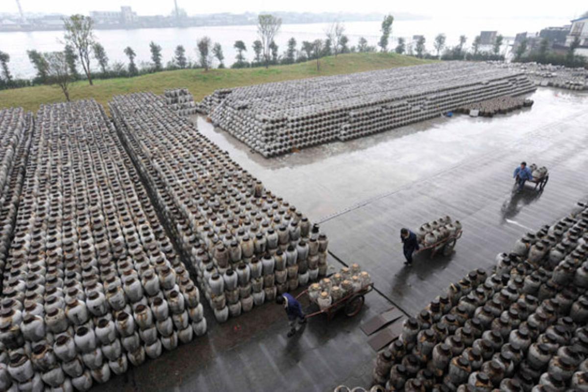 Empleats d’una fàbrica de vi carreguen bidons, a Shaoxing, província de Zhejiang (Xina).