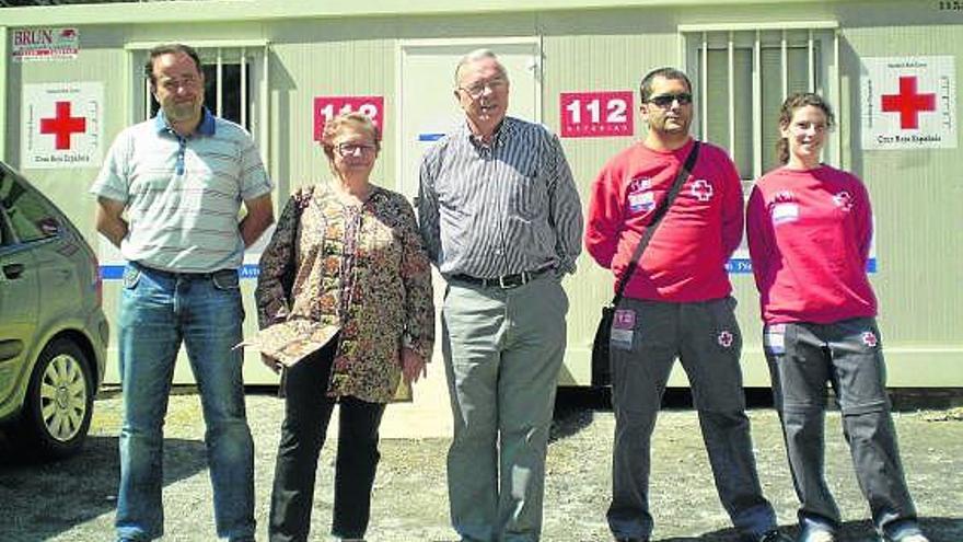 Un grupo de turistas, en la carretera de Poncebos, con decenas de coches aparcados.