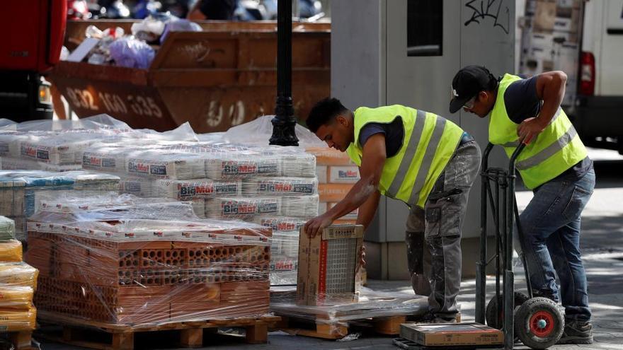 Dos trabajadores en una obra en la calle.