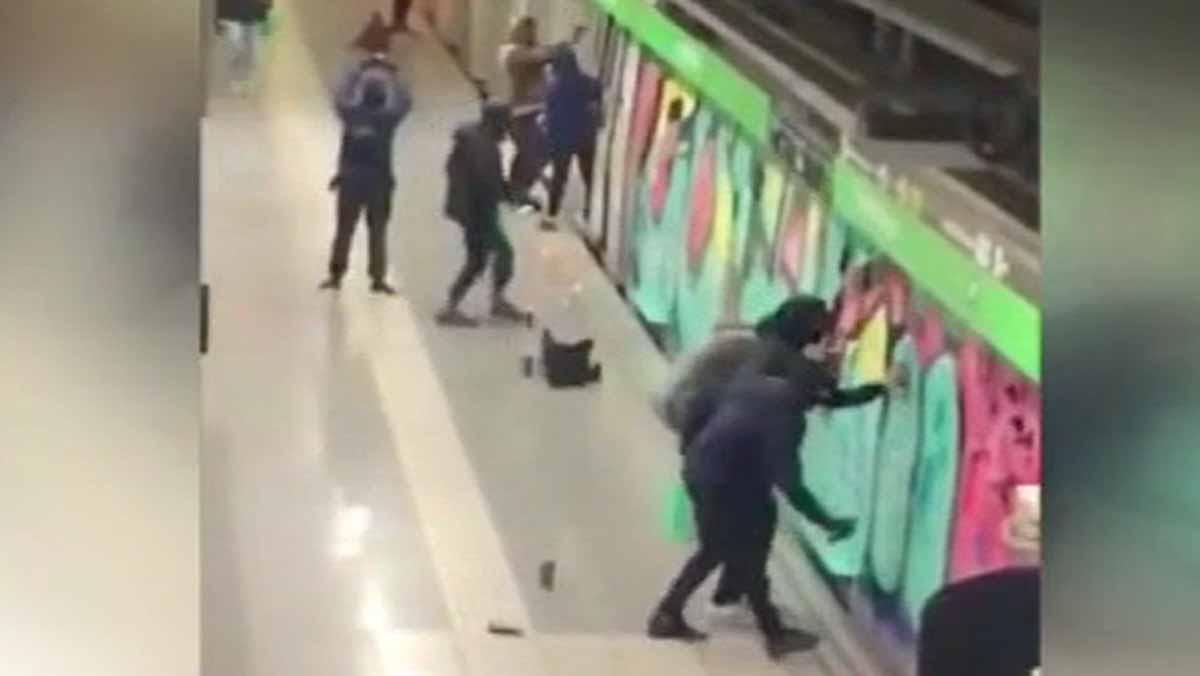 Una vintena de grafiters pinten diversos dels vagons de dos combois de la línia 3 del metro de Barcelona davant la mirada impotent dels guàrdies de seguretat.