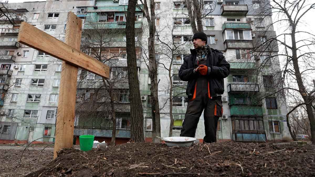 Un ciudadano de Mariúpol junto a la tumba de un amigo, muerto durante un ataque ruso en la localidad ucraniana