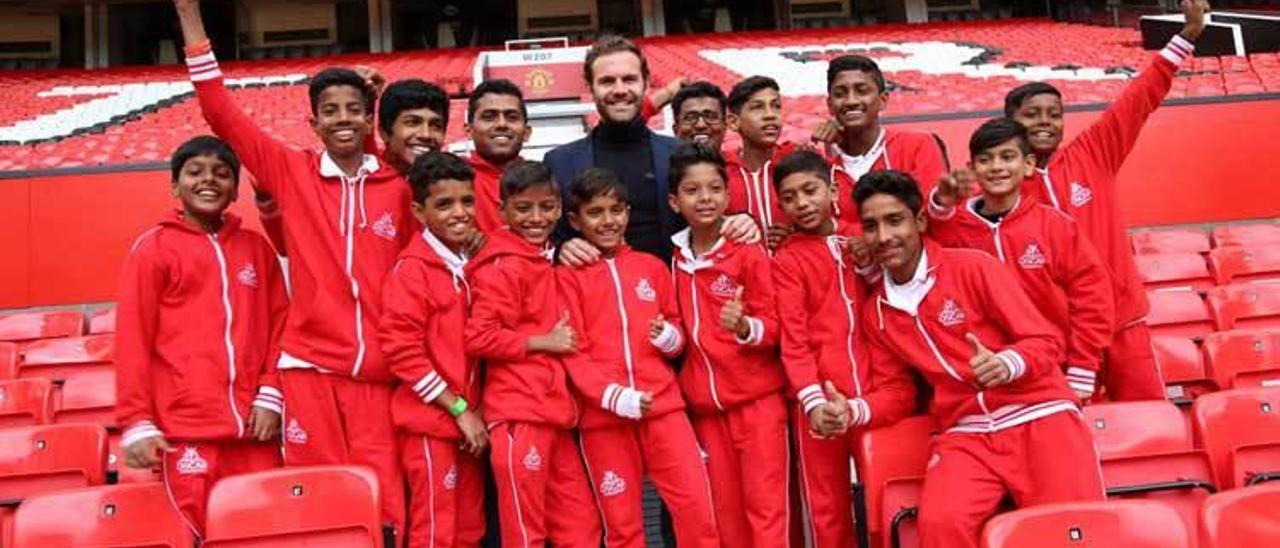 Juan Mata posa con niños de Mumbai (India) en la grada de Old Trafford.