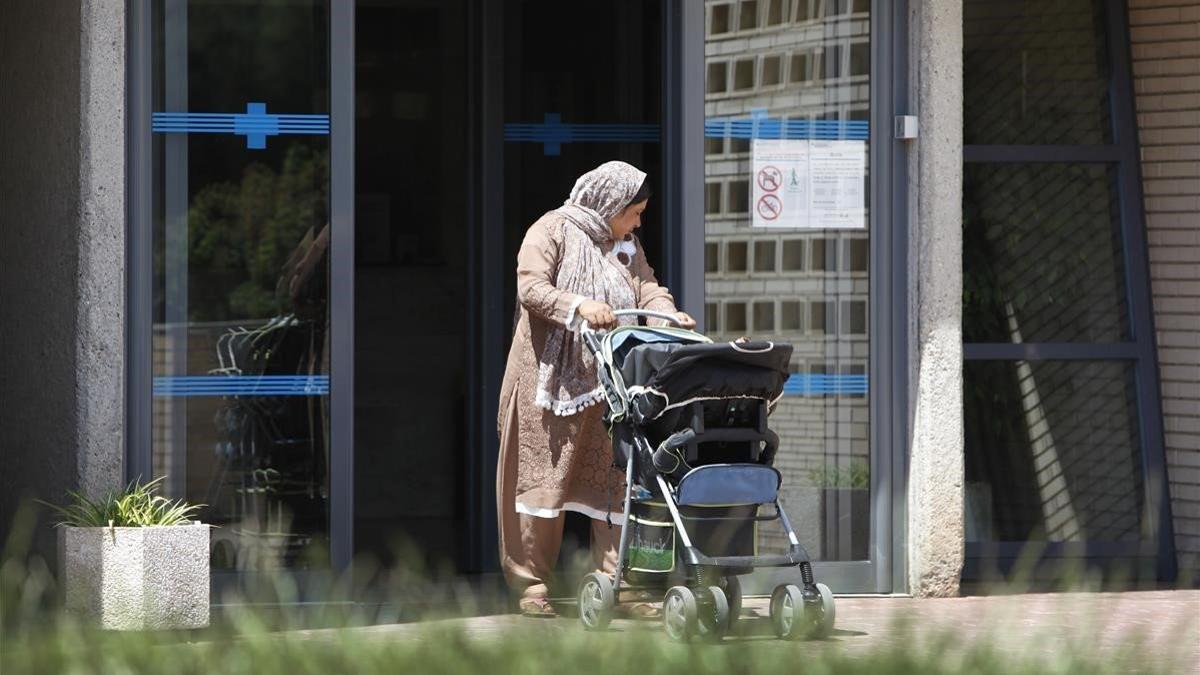 Una mujer inmigrante delante de un centro sanitario