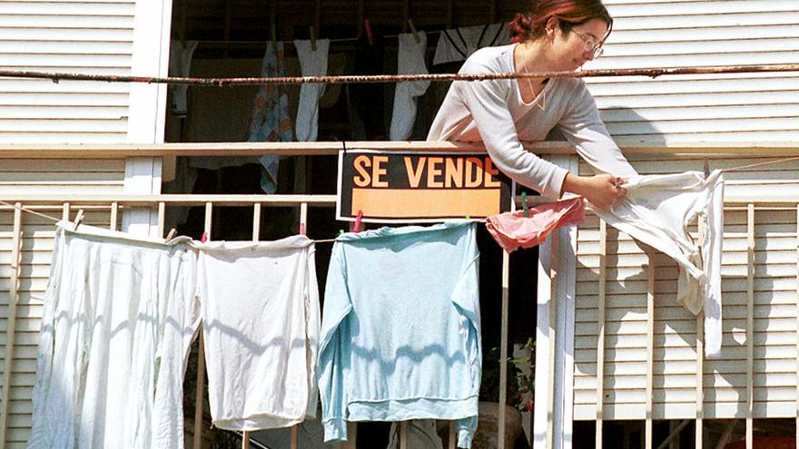 Una vecina tiende su ropa en el balcón de su piso en venta. / El Correo