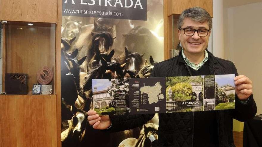 El edil de Turismo muestra el folleto promocional general ante la vitrina itinerante.  // Bernabé / Javier Lalín