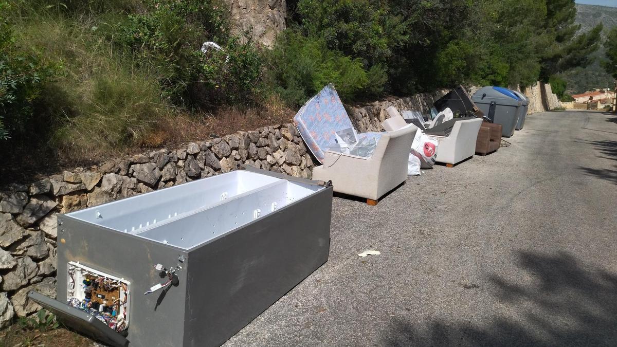 Enseres domésticos tirados junto a contenedores de basura en Calp
