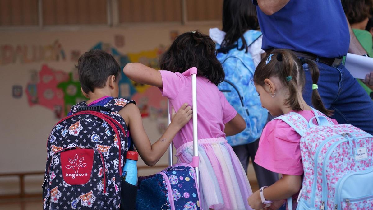 Tres niños entran a un colegio en una imagen de archivo.