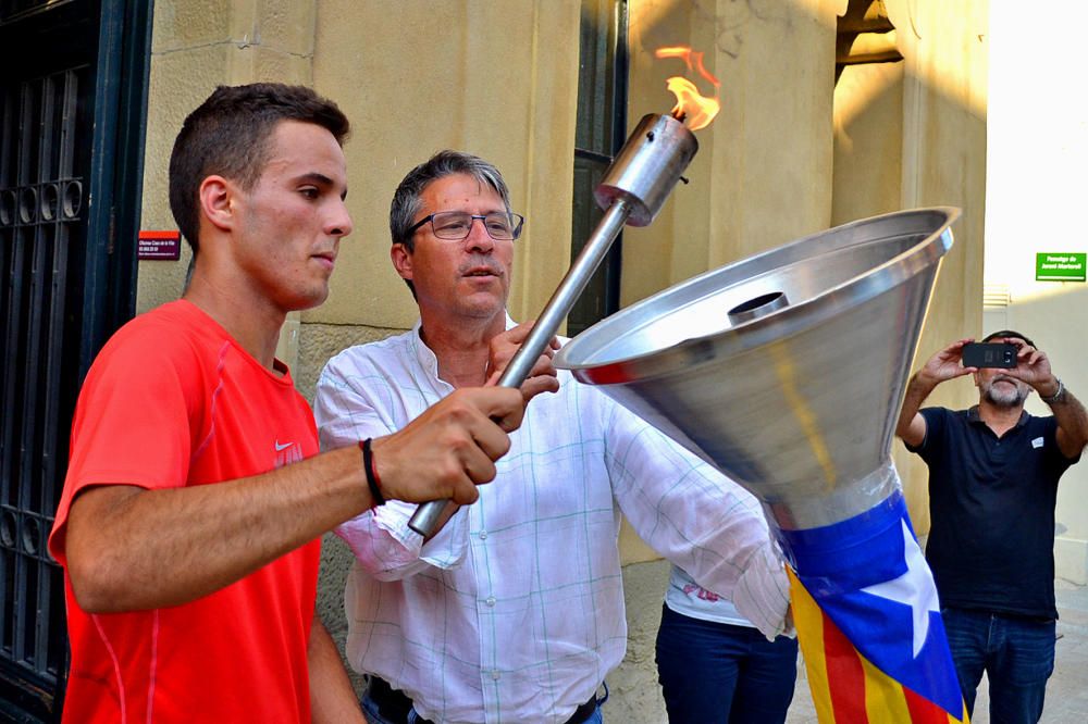 Encesa del peveter de la Flama del Canigó al davant de la Casa de la Vila, amb l'alcalde Josep Maria Canudas i un dels esportistes portadors, dins de la celebració de la Nit de Sant Joan a Súria