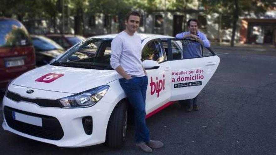 Los responsables de Bipi con un coche de su flota.