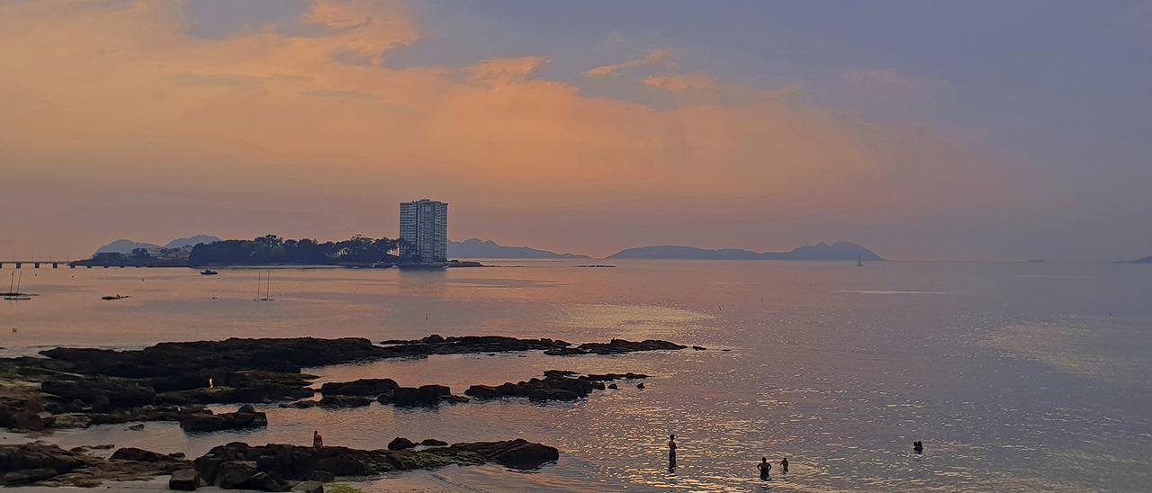 Imagen de una puesta de sol en la playa de O Vao, en Vigo, con la isla de Toralla y las Cíes al fondo