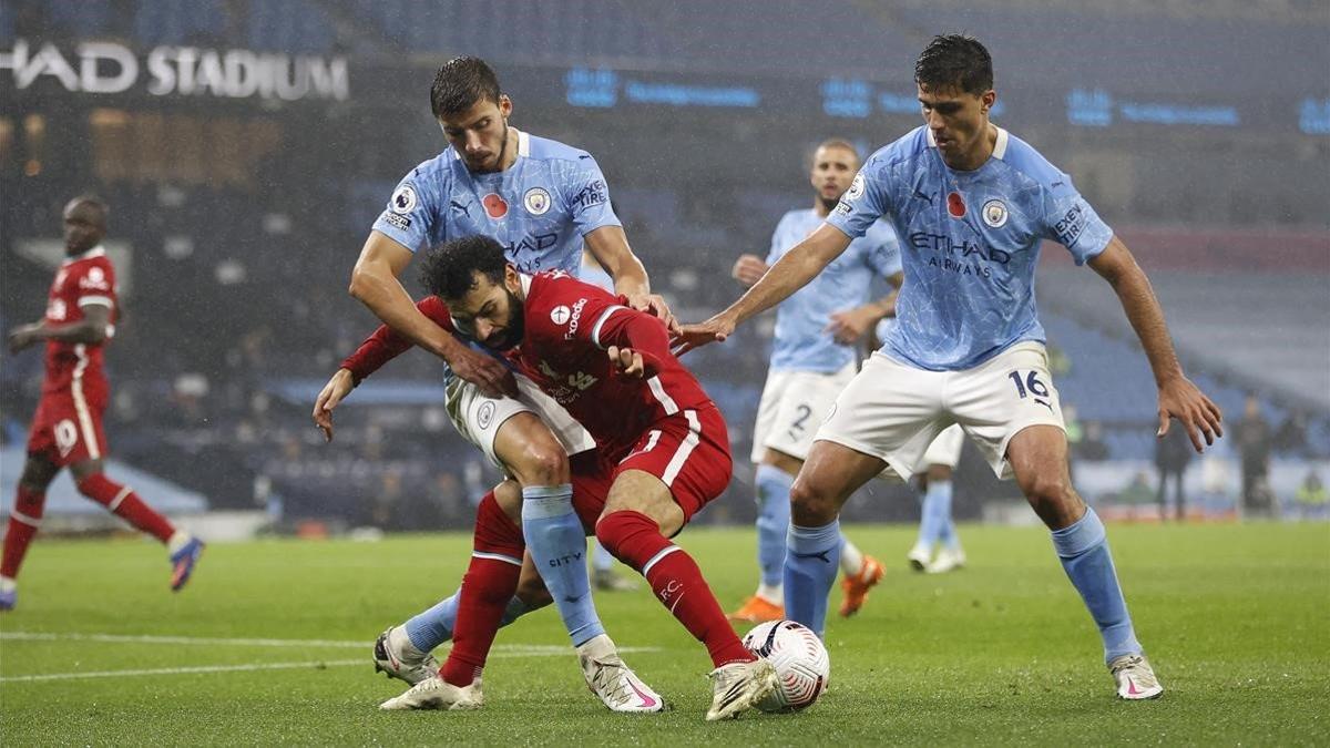 Salah pelea un balón ante Dias y Rodri.