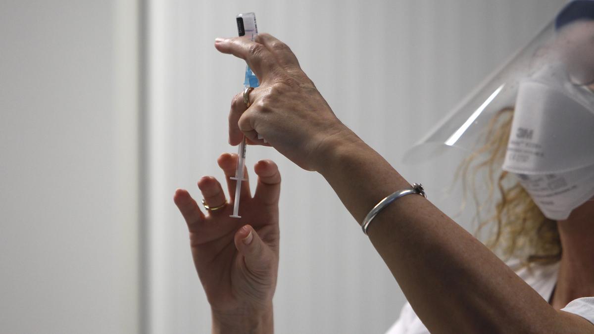 Una mujer sanitario prepara una vacuna.