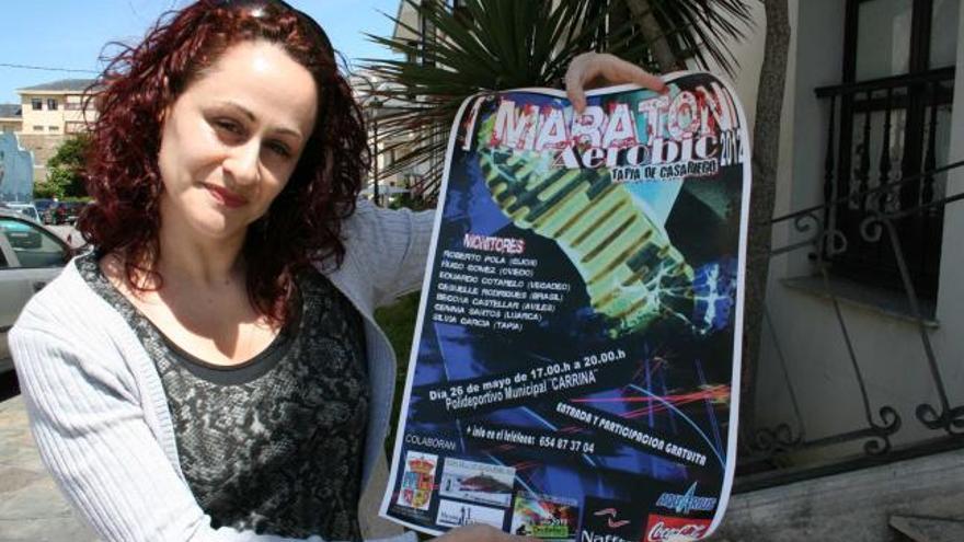 La monitora Silvia García muestra el cartel de la convocatoria en Tapia.