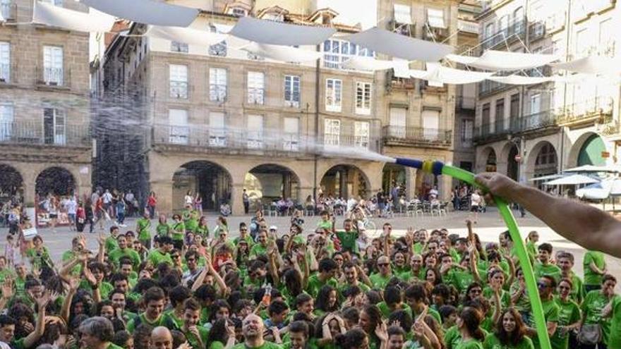 Un baño solidario con mangueras en la praza Maior de Ourense.